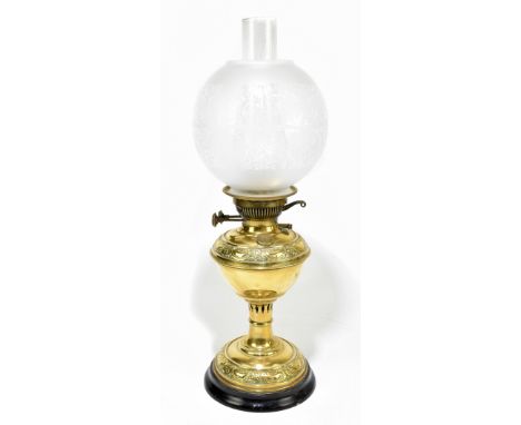 A late 19th century brass oil lamp with foliate scroll relief detail, etched globe in clear chimney, two insets to burner, st