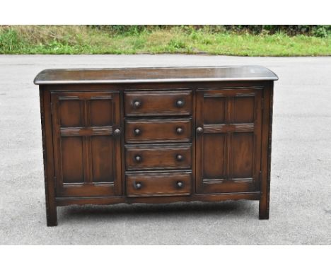 A 1930s stained oak sideboard, with four central drawers flanked by two panelled cupboard doors, on stile feet, height 89cm, 