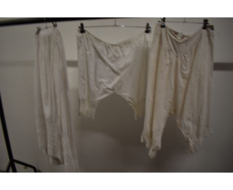 Two Victorian petticoats having lace work and pin tucks to hems, a pair of knickers having crotchet bands to cuffs and a pair
