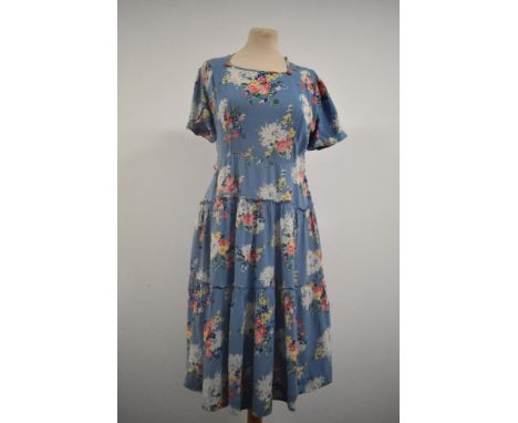 A late 1930s day dress in blue floral cotton having side metal zip, tiered skirt and square neckline with self covered button