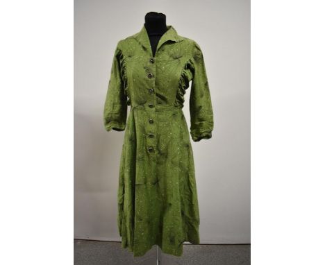 A 1950s vibrant pea green cotton day dress having atomic print and long sleeves, rusched panels to sides of bodice and button