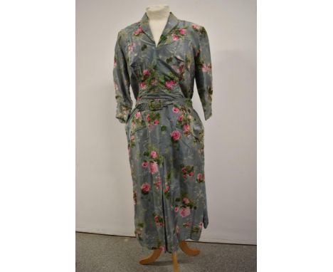 A 1940s duck egg blue dress having rose pattern in pink, side metal zip, three quarter length sleeves and belt with attached 