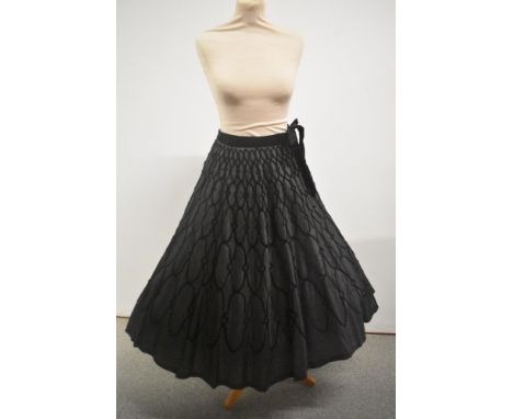 A late 1940s evening skirt having flocked black velvet pattern throughout and velvet ties to waist, replacement zip, some mar