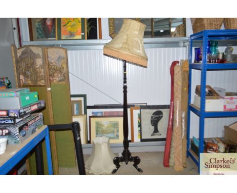 A standard lamp raised on paw feet with two shades