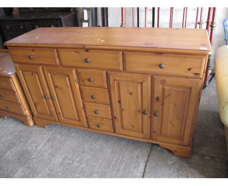 Ducal Tuscany pine sideboard with an arrangement of short and long drawers and cupboards on bracket feet. 