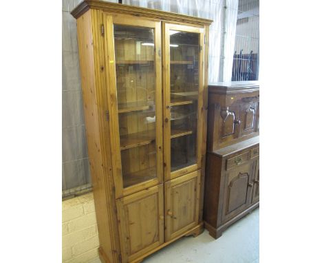 Modern pine two door display cabinet on bracket feet. 