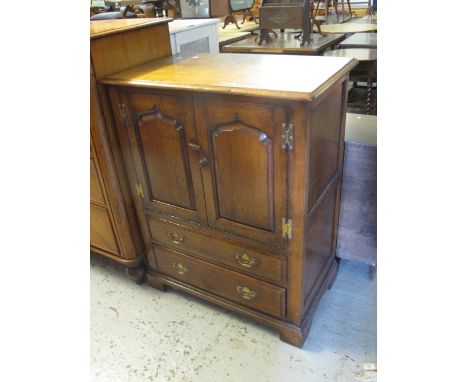 Reproduction oak two door blind panelled TV unit with fitted drawers on bracket feet. 