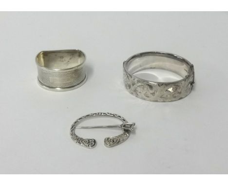 A silver napkin ring, bangle and celtic pin (3).