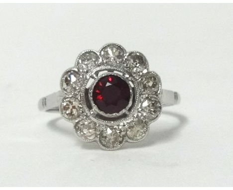 A platinum ruby and diamond cluster ring, finger size M.