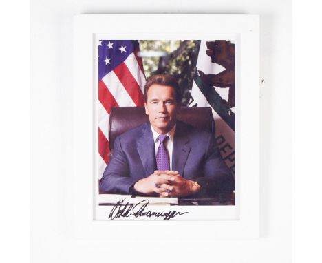 This framed portrait features Arnold Schwarzenegger in his official capacity as Governor of California, seated at his desk wi