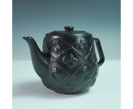 A KAWS × black ceramic teapot featuring the artist’s signature Companion face motif in a quilted pattern. After his first Tea