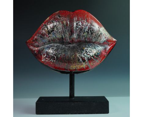 A mixed media pop art sculpture by artist Khalil Douisse. The piece consists of a giant lips attached to a glittery black bas