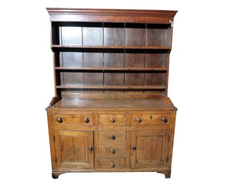 An early 19th century North Walian oak and pine highback dresser.  With a cavetto cornice above a plain frieze, three plate r