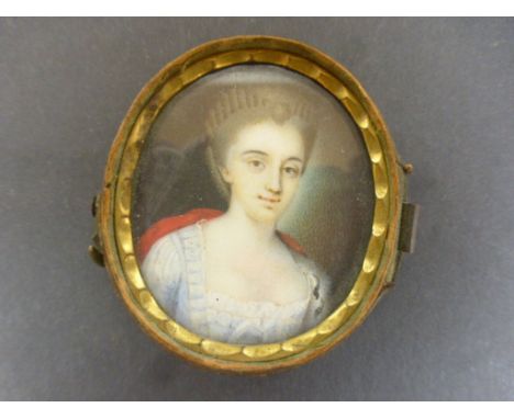 Hand painted oval portrait miniature depicting a woman wearing a pale blue dress with red cape, framed in leather case (missi