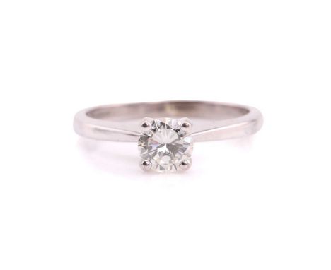 A single stone diamond ring, the round brilliant cut diamond in simple raised claw mount; to tapering shoulders and plain 18 