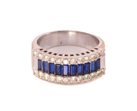 A three-row sapphire and diamond dress ring, set with a central tramline of baguette-cut synthetic sapphires, and brilliant d