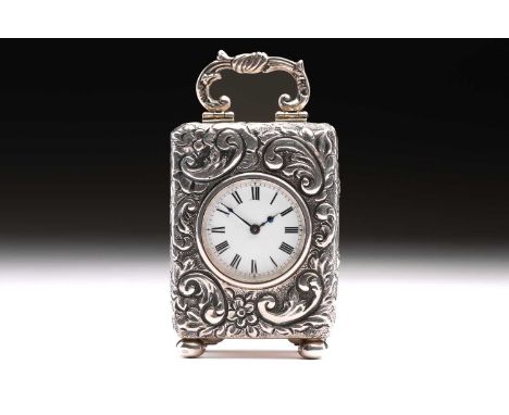 A late Victorian miniature silver carriage clock; the circular white enamel dial with Roman numerals; the case profusely deco