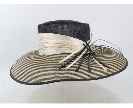 A Vivien Sheriff ladies straw hat - with a broad black and natural striped brim and black crown with cream silk band.