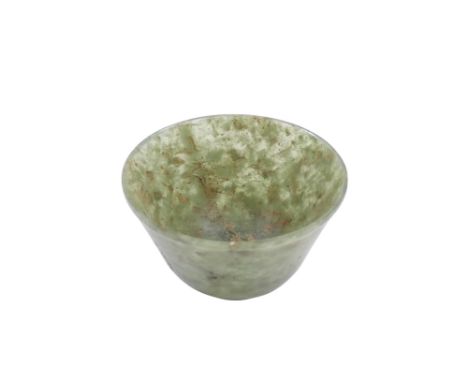 A Chinese spinach jade bowl - with slightly overted rim and raised on a foot, 6cm diameter.