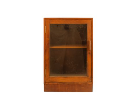 An early 20th century teak cabinet - with a glazed panel door enclosing a shelf, 37 x 26 x 56cm.