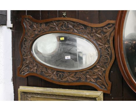 Arts &amp; Crafts carved framed bevel edged oval mirror, 49 x 73 cm