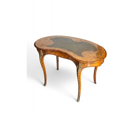 A Victorian burr walnut and floral marquetry kidney shaped writing table applied with gilt bronze mounts in the manner of Gil
