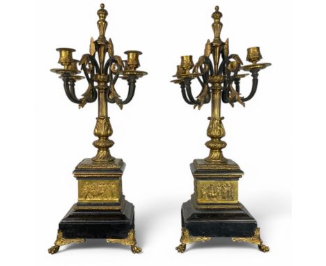 A pair of 19th century bronze, ebonised and black marble four-light candleabra In the neo-classical style, the scrolling leaf
