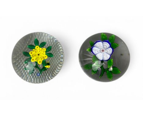 Two 19th century French floral paperweights One of a primrose with star cut base, possibly Baccarat, 7cm diameter, the other 