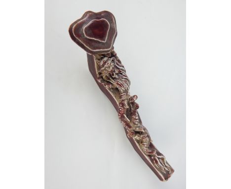 Chinese ceramic ruyi scepter, ox blood glaze and dragon decoration, 28cm l