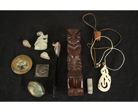 A collection of items including a carved bone Maori pendant, polished ammonite, two ceramic tortoises and other collectibles.