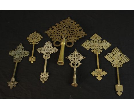 Seven Ethiopian Coptic brass and silver plated hand crosses, two with engraved detailing. H.36 W.26cm. (largest) 