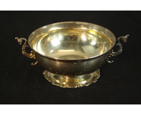 A sterling silver Egyptian twin handled porringer with seahorse form handles on a pedestal foot. Egyptian silver marks to bas