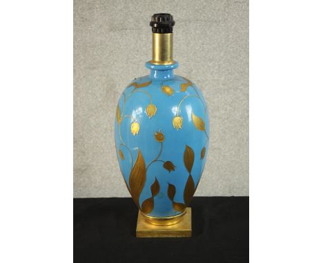 A contemporary gilded and blue opaque glass painted table lamp, of ovoid form and on a square gilt metal base. H.46 Dia.20cm.