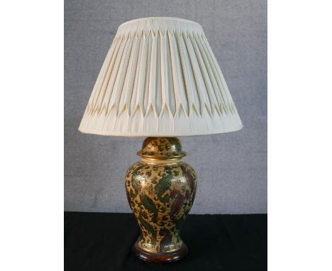 An Oriental printed and gilded stylised foliate design ceramic urn table lamp with pleated silk shade. H.64cm 