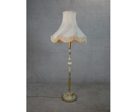 A circa 1970's onyx and brass standard lamp, with a circular base on paw feet and shade. H.159 W.59cm 