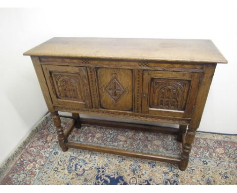 Titchmarsh &amp; Goodwin style oak side cabinet, lozenge panel and two arched carved doors on turned supports with stretchers