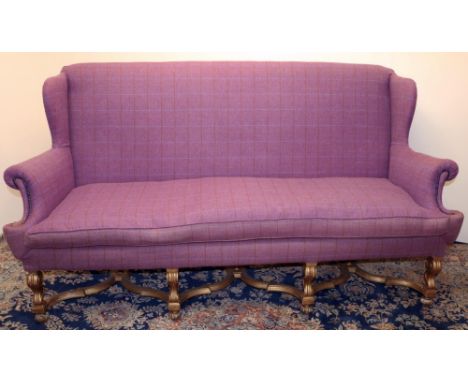 Queen Anne style sofa with wing back and outsplayed arms, on gilt angular S-scroll legs with bun feet joined by cross stretch