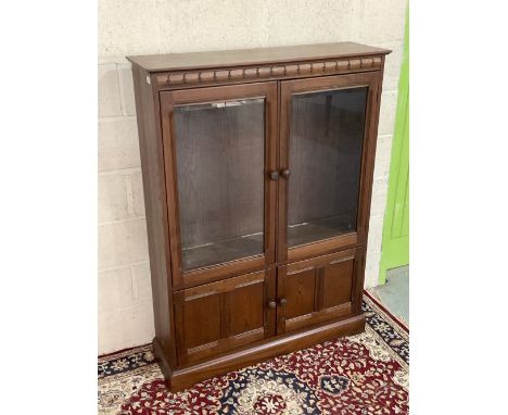 Ercol dark display cabinet with two adjustable shelves, two glazed and two panel doors, on a skirted base, Design 724 on gree