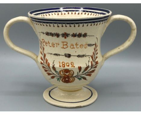 C20th Prattware loving cup painted 'Peter Bates 1802' in floral wreath, H13cm 