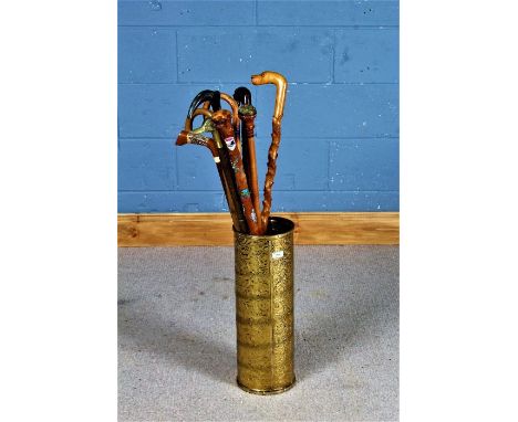 Brass embossed cylindrical stick stand, with contents of nine various walking sticks