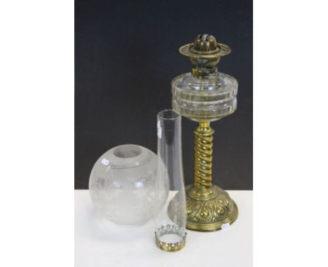 An antique table top oil lamp with Art Nouveau base, with twisted stem and glass well