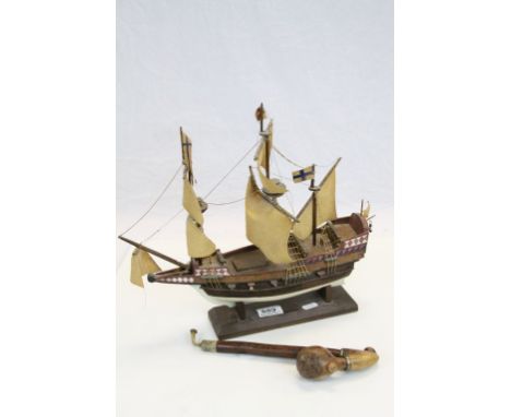 A vintage pipe with carved bird decorated bowl and a model sailing ship on stand 
