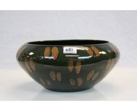 A studio bowl in the style of Poole Pottery, green ground with brown fleck decoration, unmarked 