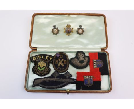 A Collection Of Vintage Military Metal And Cloth Badges To Include Enamel ASC Collar Badges And Infantry Cloth Badges.
