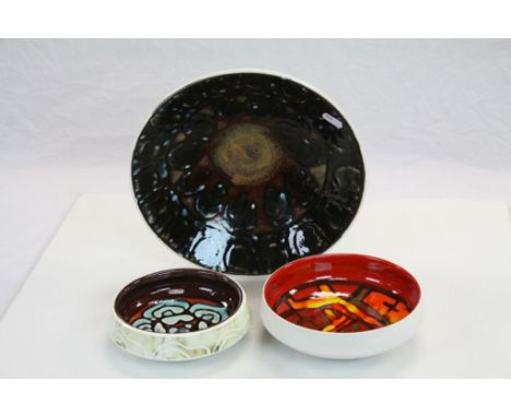 Three Poole Delphis Pottery ceramic dishes, the largest approx 27.5cm diameter, the smallest with incised decoration to the e