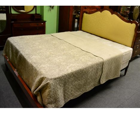 A rosewood and satinwood double bed with serpentine upholstered headboard and bed spread 