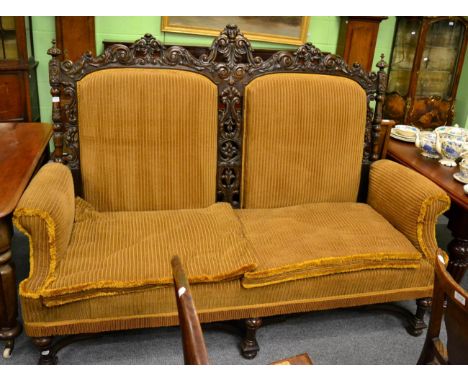 A large Victorian carved sofa with yellow upholstery 