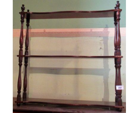 A mahogany three tier book shelf.