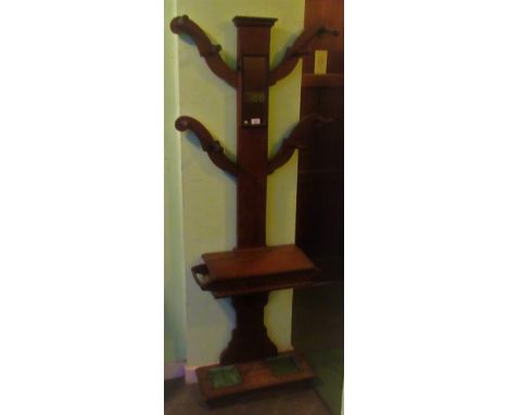 A 20th century oak hall stand, having eight coat hooks, central mirrored panel, key and glove drawer and stick stand.