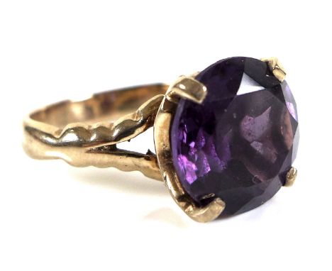 A 9ct gold and amethyst ring, the single circular stone of 12mm, with split and shaped shoulders, size M, 5.7g. 